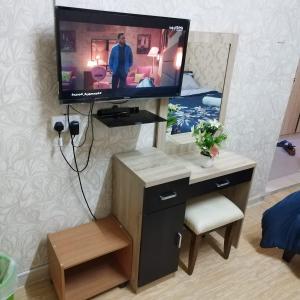 a tv sitting on top of a dresser in a room at العين الهيلي مصباح بيت 12 in Al Ain