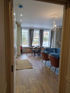 a living room with a blue couch and a table at Garden Beach Apartment, Hunstanton Norfolk in Hunstanton