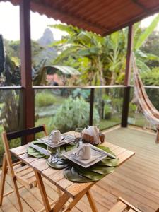 uma mesa de madeira com um prato de comida num deque em Terras Verdes Residence em Fernando de Noronha