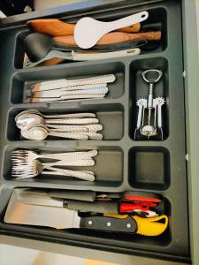 a drawer filled with utensils and other kitchen items at Dream Dwell Paris-Cozy historic appartement near Exelmans in 16th District Paris in Paris