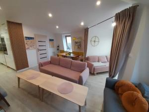 a living room with a couch and a table at Apartament Puck Przestronny i Nowoczesny in Puck