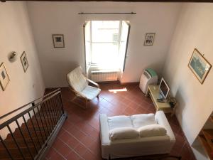 ein Wohnzimmer mit einer weißen Couch und einem Stuhl in der Unterkunft L'Orbetellana - Guest House in Orbetello