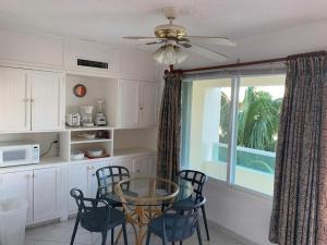 cocina con mesa, sillas y ventana en Suites Brisas Cancun, en Cancún