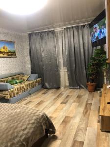 a bedroom with a bed and a flat screen tv at Квартира Пентагон in Korostenʼ