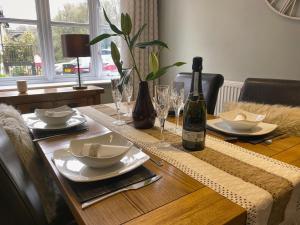uma mesa de jantar com uma garrafa de vinho e copos em Luxury Home With Stunning River Views em Knaresborough