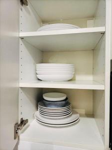 a white cabinet with plates and bowls in it at Dream Dwell Paris-Chic flat in the heart of Marais near Pompidou Centre in Paris