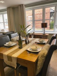 a dining room table with a bottle of wine on it at Luxury Home With Stunning River Views in Knaresborough