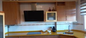a kitchen with a sink and a tv on the wall at Casa Rotella in Puente San Miguel