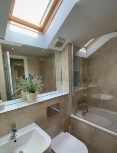 La salle de bains est pourvue d'un lavabo, de toilettes et d'une baignoire. dans l'établissement Luxury Home With Stunning River Views, à Knaresborough