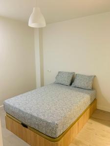 um quarto com uma cama com duas almofadas em Pisos con Piscina Barrio Exclusivo-WizinkCenter em Madri