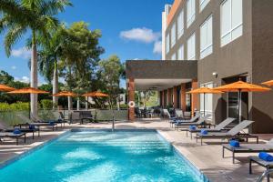 una piscina con sedie e ombrelloni accanto a un hotel di Four Points by Sheraton  a Punta Cana