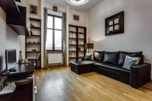 リヴィウにあるStylish Apartment - Ivana Franka Streetのリビングルーム(黒い革張りのソファ、テレビ付)