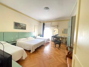 ボローニャにあるHotel Panorama Bologna Centroのベッド2台とテーブルが備わるホテルルームです。