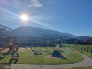 a park with playground equipment with mountains in the background at little alpenapart in Volders
