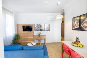 a living room with a blue couch and a table at Comfort Suites in Alanya