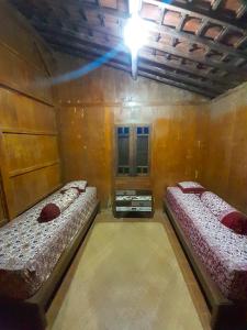 a room with two beds and a light on the ceiling at Omah Mbah Manten in Tuntang