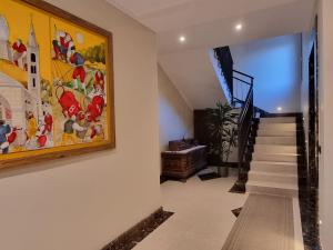 un escalier dans une maison ornée d'une peinture murale dans l'établissement Maison de l'Envers, à Aoste