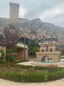 um edifício de pedra com uma montanha ao fundo em Apartamentos Nenufar em Alhama de Aragón