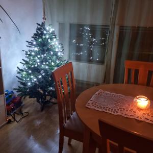 a christmas tree in a living room with a table at Juuli apartament in Kuressaare