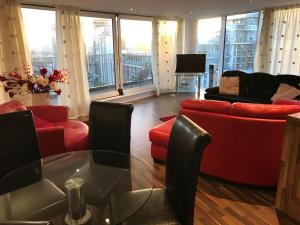 - un salon avec des canapés rouges et une table en verre dans l'établissement EXCEL STUNNING DUPLEX PENTHOUSE, à Londres