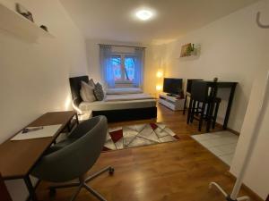 una sala de estar con cama y escritorio y una habitación con sofá en Einzimmerwohnung in Kassel Mitte, en Kassel