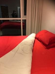 - un lit rouge et blanc avec 2 oreillers rouges dans l'établissement EXCEL STUNNING DUPLEX PENTHOUSE, à Londres