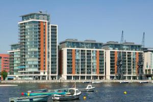 two boats in the water in front of tall buildings at EXCEL STUNNING DUPLEX PENTHOUSE in London