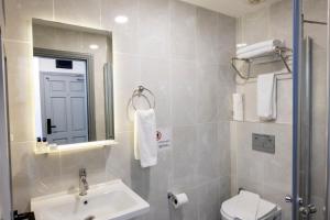 uma casa de banho com um lavatório, um WC e um espelho. em Comfort Suites em Alanya