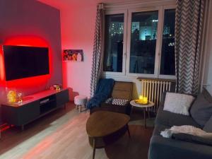 a red living room with a couch and a tv at Perle rare aux portes de Paris in Ivry-sur-Seine