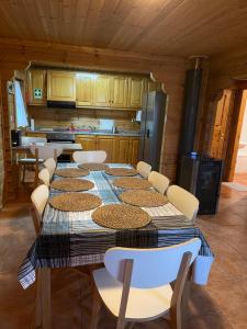 a long table with chairs and a kitchen in a room at Chalé do Sossego Serra da Estrela in Cortes do Meio