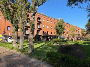 a large brick building with trees in front of it at Beautiful apartment in Puerto Madero in Buenos Aires