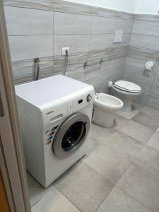 a washing machine in a bathroom with a toilet at Mary's House in SantʼEufemia Lamezia