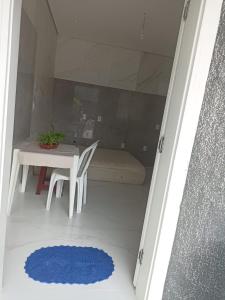 um quarto com uma mesa, uma cadeira e um tapete azul em Winter X locações 03 em Itapema