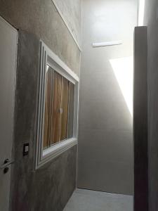 ein Bad mit einer Tür und einem Fenster in der Unterkunft Winter X locações 03 in Itapema