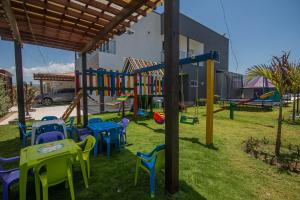 un patio con parque infantil con mesas y sillas en Casa Bita Morales CASA 101, en Las Canoas