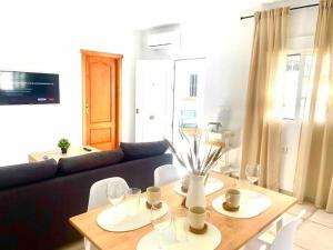 ein Wohnzimmer mit einem Tisch und einem Sofa in der Unterkunft Brisa Home in Chiclana de la Frontera