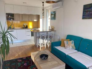 a living room with a blue couch and a kitchen at Sunset Panorama in Sarajevo