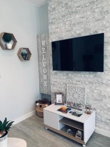 a living room with a tv on a brick wall at Apartamentos Nenufar in Alhama de Aragón