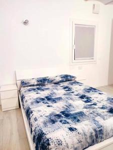 een slaapkamer met een blauw en wit bed en een raam bij Casa Spaziosa in centro Paese in Inzago