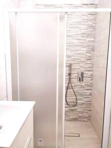 een badkamer met een douche en een glazen deur bij Casa Spaziosa in centro Paese in Inzago