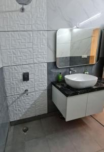 a bathroom with a sink and a mirror at Rosset-57, Cosy Stay & luxury party place in Faridabad