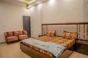 a bedroom with a bed and a couch and a chair at Rosset-57, Cosy Stay & luxury party place in Faridabad