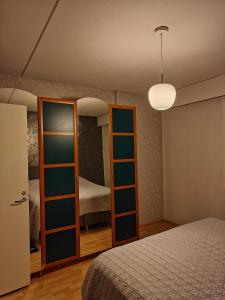 Schlafzimmer mit einem Bett und einem Spiegel in der Unterkunft Js House in Pori