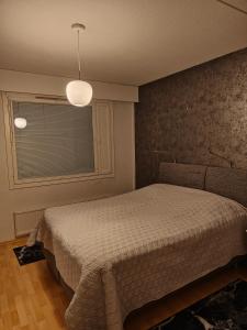 um quarto com uma cama e uma janela em Js House em Pori