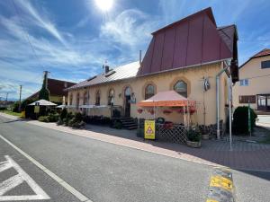 een gebouw met een rood dak aan de straatkant bij Penzion Manderlak in Liptovský Mikuláš