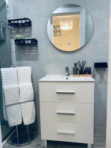 a bathroom with a white sink and a mirror at Apartamentos Nenufar in Alhama de Aragón