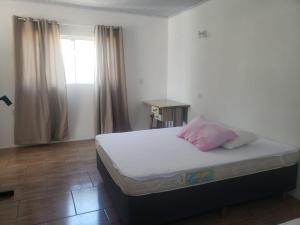 Apartamentos de Verão في ترامانداي: غرفة نوم عليها سرير ومخدة وردية