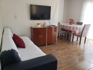 ein Wohnzimmer mit einem Sofa und einem Tisch in der Unterkunft Apartamentos de Verão in Tramandaí