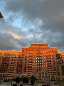 un gran edificio naranja con un cielo nublado en el fondo en Green Plaza 10-11, en Aktau