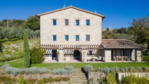 an external view of a stone house with a garden at CASALE ORTALI - Miani Group in Pesciano